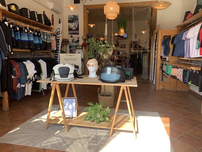 L'interno del Kitesurf Shop Reef con trapezi, mute e abbigliamento da kite
